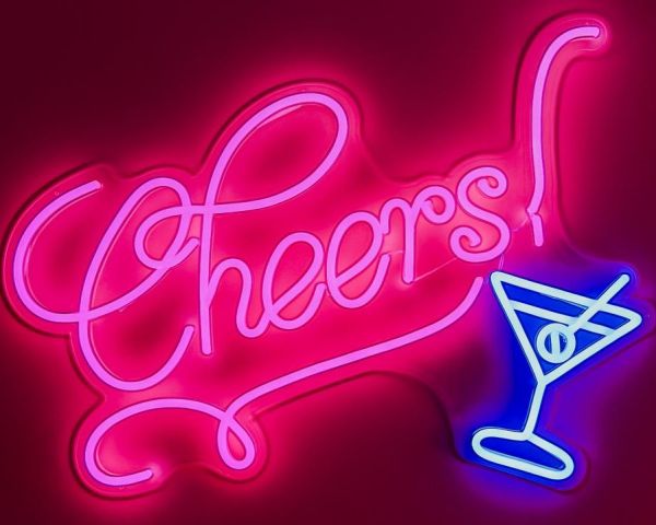 Pink and blue LED neon sign of the word Cheers in a retro script font with a martini glass - by Custom Neon®