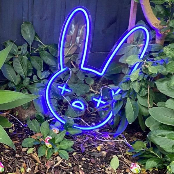 Custom Neon® blue bad bunny emoji LED art shown as lighted decor for an Easter egg hunt