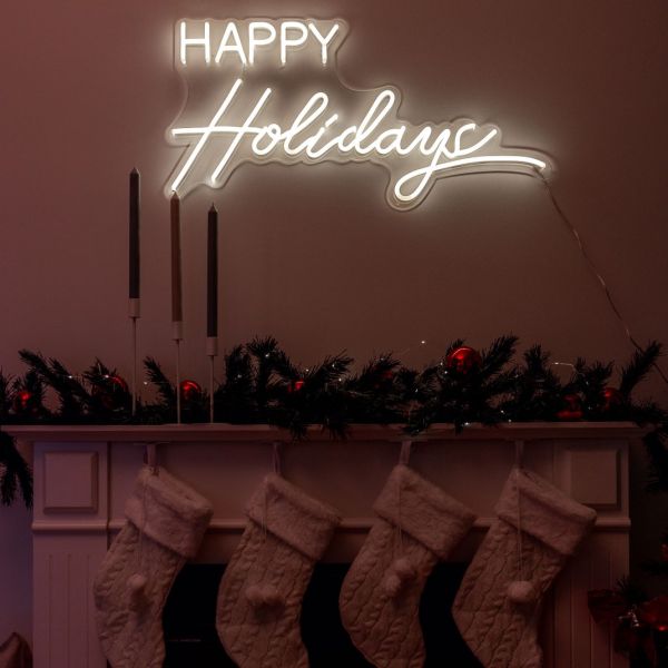 CUSTOM NEON® Happy Holidays light sign above the fireplace with its Christmas stockings, candles and decorations