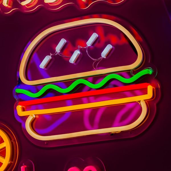 Custom Neon food sign: Hamburger with the Lot  shown illuminated against a dark wall in dim light
