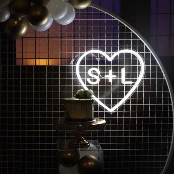 Personalized Heart Neon Sign in LED Flex with clear acrylic background displayed with balloons and wedding cake - photo from CustomNeon.com