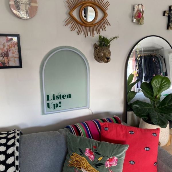 Listen Up! white & green neon art shown turned off & wall mounted above a sofa @customneon Signs of Change charity range