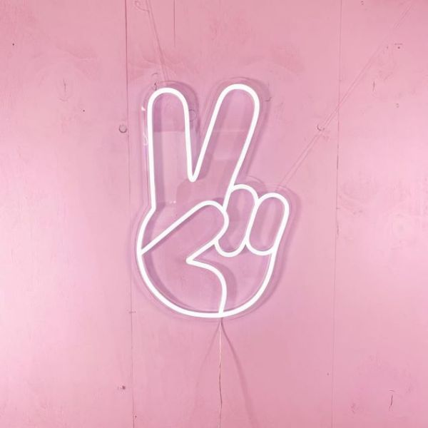 LED Neon Peace Emoji Sign Light shown on a pink wall - Photo CustomNeon.com