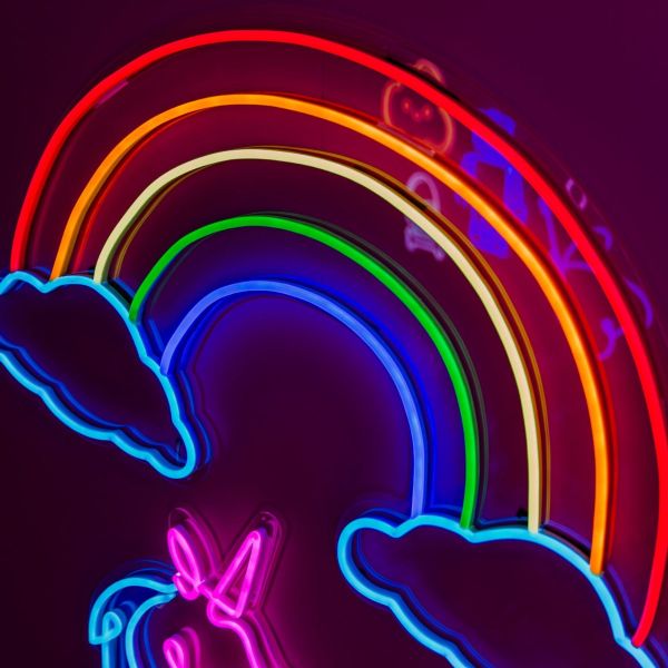 Rainbow & Clouds Custom Neon® light shown illuminated on dark background in dim light