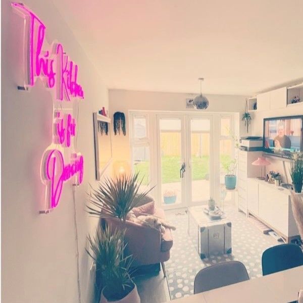 Pink neon sign shown wall mounted in a dining/living room @thekingsnewcastle by Custom Neon