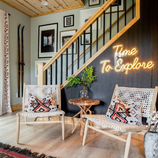 Time to Explore warm white LED neon sign on a dark wood panel wall beneath the staircase in a ski cabin - CUSTOM NEON™ x SOMERLED COLLECTION