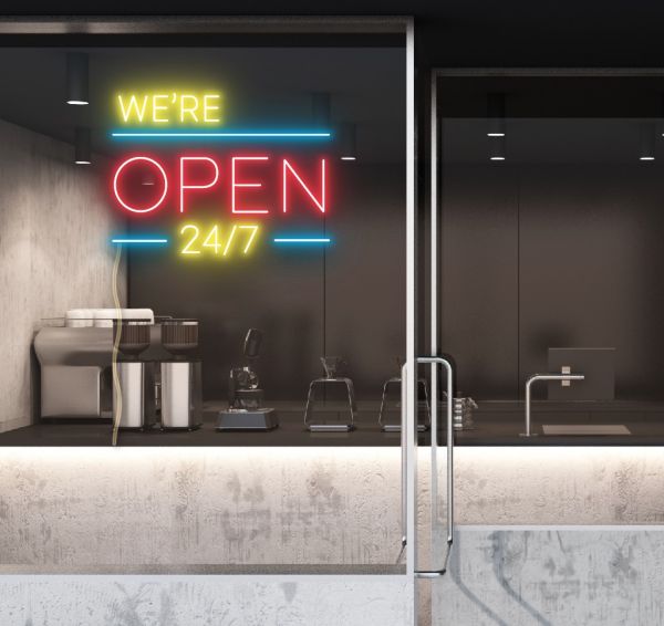 WE'RE OPEN 24/7 in brilliant yellow and red, with bright blue lines shown in a cafe window - from CustomNeon.com