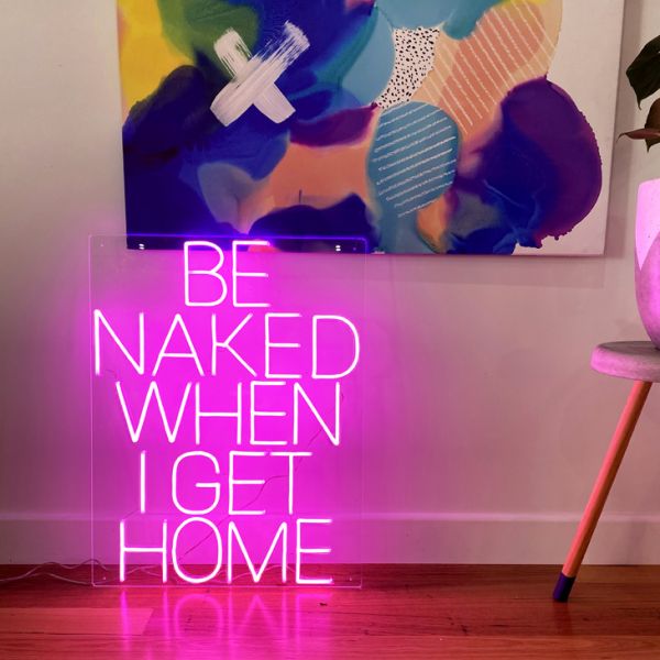 Be Naked When I Get Home LED neon sign shown on the floor beneath a painting - photo from CustomNeon.com