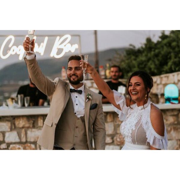 Cocktail Bar Neon Sign shown behind the bride and groom at a wedding - photo from CustomNeon.com