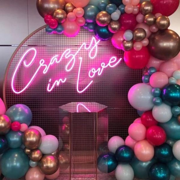 Crazy In Love Wedding Sign in brilliant LED neon flex shown in pink with balloons - photo from CustomNeon.com