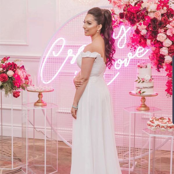 Crazy In Love Wedding Sign in brilliant LED neon flex shown in pink with the beautiful bride, wedding florals and cakes - photo from CustomNeon.com