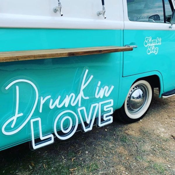 Drunk in LOVE LED Neon Light Sign for Weddings, Bars & Home Decor shown on bar van at an event  - photo CustomNeon.com