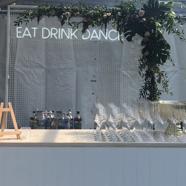 EAT DRINK DANCE neon flex sign shown behind a pop up event bar - photo from CustomNeon.com