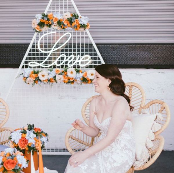 Romantic Love Sign in LED Neon Flex shown behind the bride at a wedding - from Custom Neon™