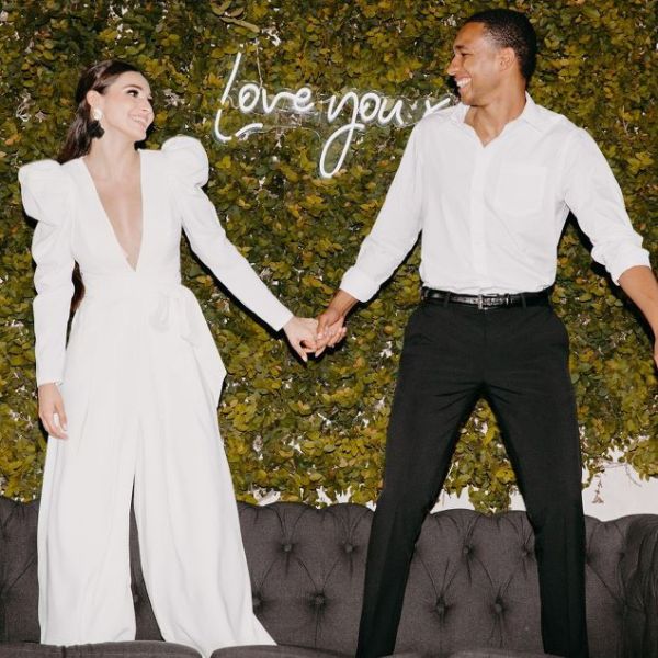 Love You XO LED neon sign on green wall while happy couple hold hands - sign by CustomNeon.com / photo by candileonardphotography.com