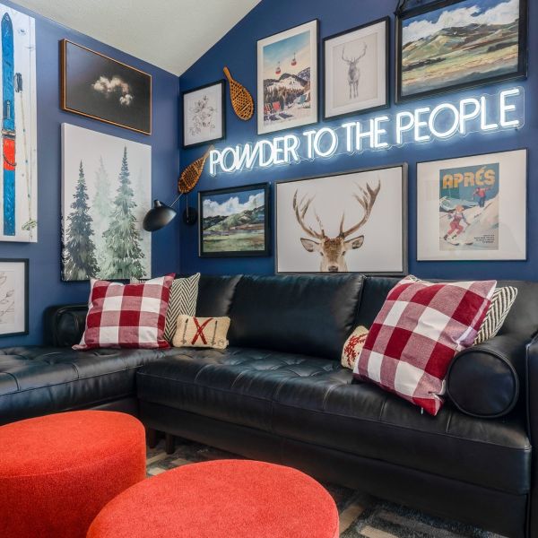 Powder to the People white LED neon sign on a blue feature wall above a black leather couch in a living room - CUSTOM NEON™ x SOMERLED COLLECTION