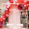Crazy in Love neon sign wall mounted on a department store display with balloons and lover's swings - photo from Custom Neon