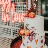 Crazy in Love LED neon wedding sign shown on mesh with a wedding cake in the foreground - photo from Custom Neon