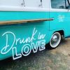 Drunk in LOVE LED Neon Light Sign for Weddings, Bars & Home Decor shown on bar van at an event  - photo CustomNeon.com