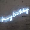 * Happy Birthday * is a lightweight, portable neon sign in modern cursive font, shown against a brick wall. 
