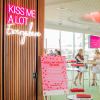 Kiss Me A Lot Everywhere LED Neon Sign shown hung from the entrance to a Valentine's Day event - photo CustomNeon.com