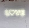 Love LED Neon Letter Light mounted on brick wall
 - photo from CustomNeon.com