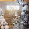 LOVE with a heart LED neon sign surrounded by wedding decorations - photo CustomNeon.com