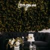 Love You XO LED neon sign on a green photo wall with a floral arrangement and cake in the foreground  - sign by CustomNeon.com / photo by candileonardphotography.com