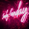 Sunday Funday neon light shown in pink displayed on a green wall - photo from CustomNeon.com