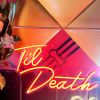 Til Death Neon Sign in LED flex shown in orange, hung from a frame at an event - photo CustomNeon.com