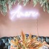 Amore CUSTOM NEON® sign in white LED neon flex shown wall mounted above a couch