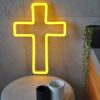 LED neon cross shown illuminated in yellow on a side table - photo from CustomNeon.com