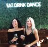 * Eat Drink Dance * Portable LED Neon Light Sign shown on a green wall at an Event - photo from CustomNeon.com