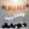 Happy Birthday illuminated sign from Custom Neon, shown on brick wall with party decorations.