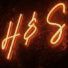 Bride & Groom Initials Neon Sign against a green wall at a wedding - photo Custom Neon®