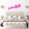 La Vie En Rose pink neon flex wall above a bed - from Custom Neon