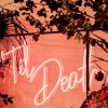 Til Death LED neon sign shown hanging from a frame at a wedding - photo from CustomNeon.com