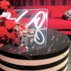 XO tabletop LED neon sign in acrylic box shown on a table during an event - photo from CustomNeon.com