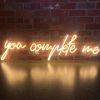 You Complete Me LED neon word light shown against a brick wall - Custom Neon®