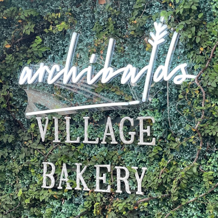 White Custom Neon® bakery logo sign @archibaldsvillagebakery