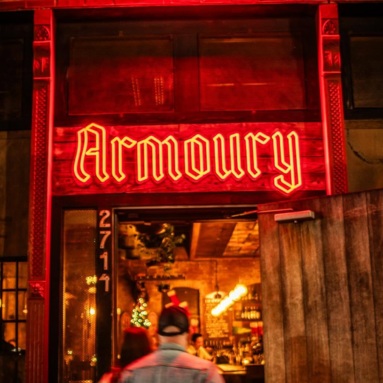 Red Armoury LED neon sign above the bar entrance at night in Deep Ellum, Dallas