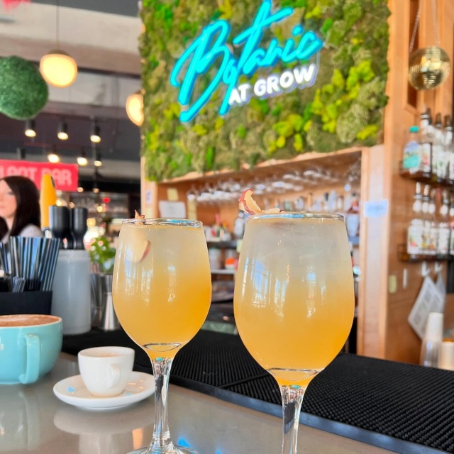 Bontanic at Grow mint and white Custom Neon® sign on a grasswall above the cocktail bar @botanicatgrow @growplantbar