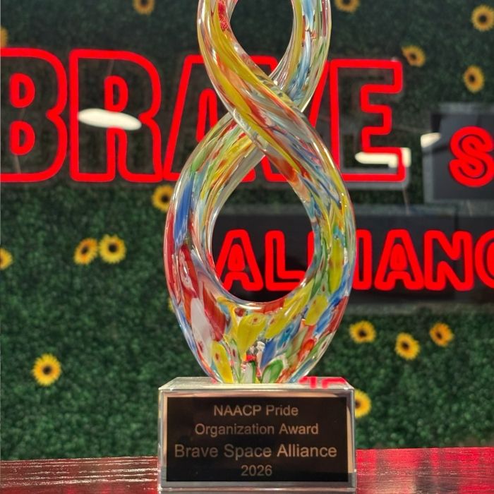Brave Space Alliance Custom Neon® sign behind a glass award trophy in Chicago