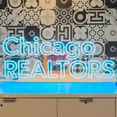 Chicago REALTORS sign in light blue LED neon on a stand