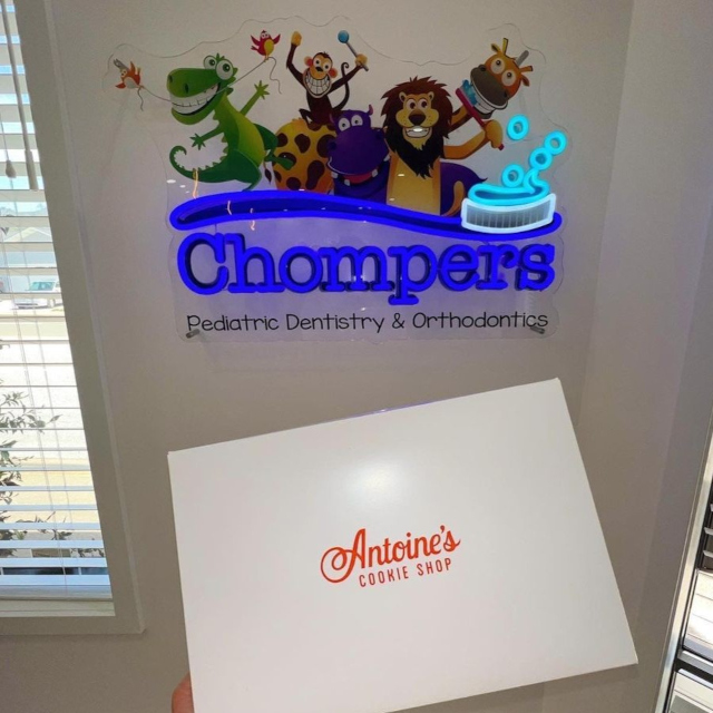 Chompers colorful logo sign on a white wall at the Chompers Dental clinic