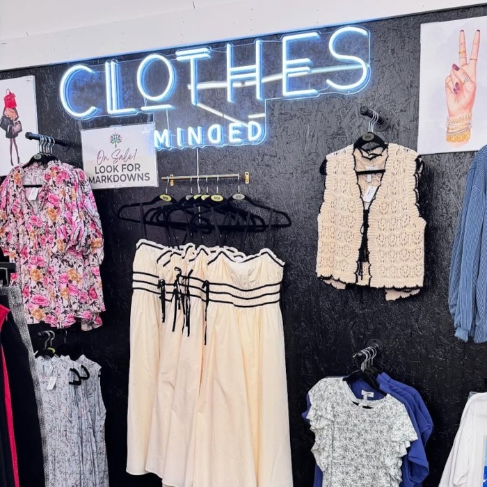 White LED Custom Neon® store sign on a grey wall above the merchandise @clothesmindedaz