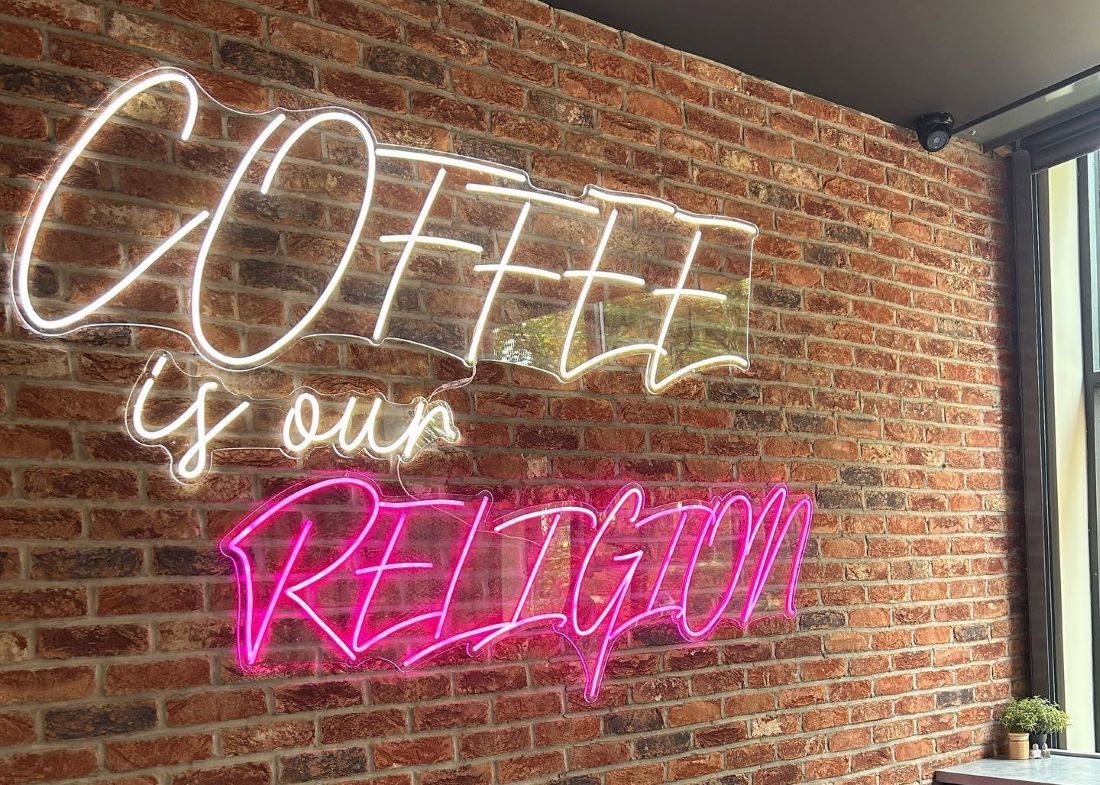 Coffee is Our Religion large Custom Neon® sign on brickwall @mayhapcoffee