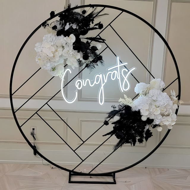 Custom Neon® white Congrats sign on black metal frame surrounded by black and white florals - event decor by @decorandfiesta