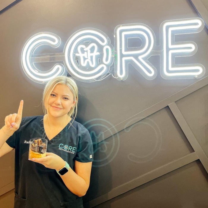 White Custom Neon® logo on the wall in the @coreorthodontics dental clinic