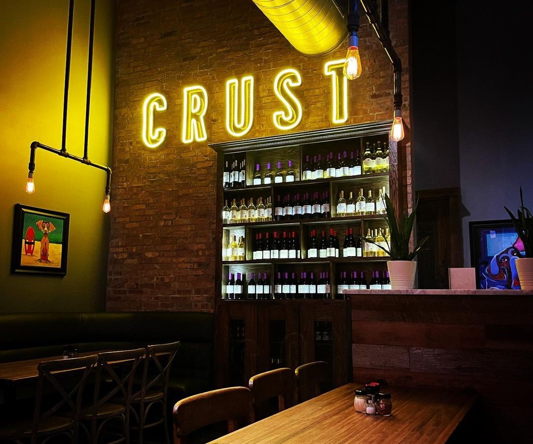Crust Custom Neon® orange LED neon logo on a brick wall